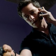 Trance: James McAvoy armato di telefono e pistola in una scena del film