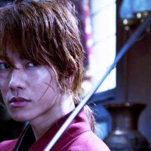 Rurouni Kenshin: un primo piano di Takeru Sato con il volto segnato dalle cicatrici