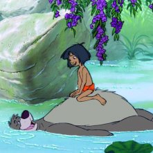Il libro della giungla: il piccolo Mowgli con l'amico orso Baloo in una scena