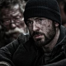 Snowpiercer: Chris Evans in un drammatico primo piano. Alle sue spalle John Hurt