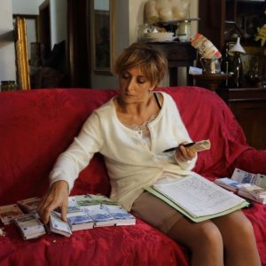 Universitari - Molto più che amici: Paola Minaccioni circondata da banconote in una scena