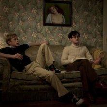 Dane DeHaan e Daniel Radcliffe seduti sul divano in una scena di Kill Your Darlings