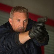 Jack Ryan - L'iniziazione: un primo piano di Kevin Costner con la pistola in pugno