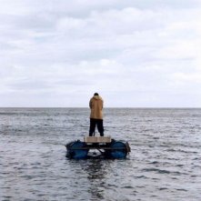 Il superstite: il protagonista George MacKay di spalle in mezzo al mare in una scena del film