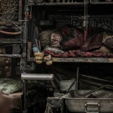 Snowpiercer: Jamie Bell rannicchiato in una cuccetta in una scena del film