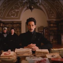 The Grand Budapest Hotel: un minaccioso Adrien Brody con alle spalle le tre sorelle