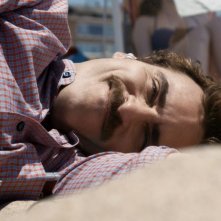 Lei: Joaquin Phoenix sdraiato sulla spiaggia in una scena del film