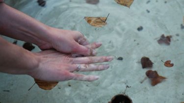 Goodbye to language: mani di donna nell'acqua in una scena del film