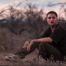 The Rover: Robert Pattinson seduto nella polvere in una scena del film