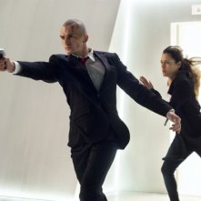 Hitman: Agent 47, Rupert Friend sfodera la pistola, mentre Hannah Ware corre insieme a lui
