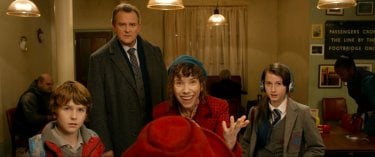 Paddington: l'orsetto Paddington familiarizza con i Brown in una scena del film