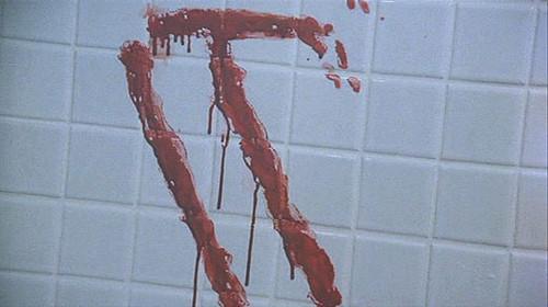 Primo piano di Tim Curry nel ruolo di Pennywise in IT