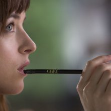 Cinquanta sfumature di grigio: Dakota Johnson tiene una matita in bocca mentre riflette