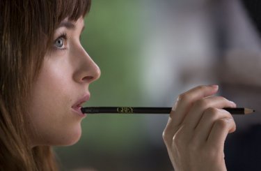 Cinquanta sfumature di grigio: Dakota Johnson tiene una matita in bocca mentre riflette