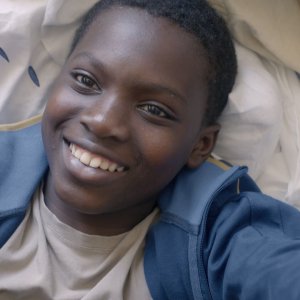 La vie en grand: Balamine Guirassy in un primo piano sorridente tratto dal film