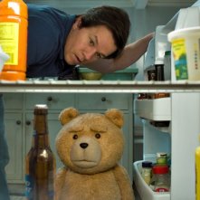 Ted 2: l'orsacchiotto Ted e Mark Wahlberg scrutano nel frigo in una scena del film