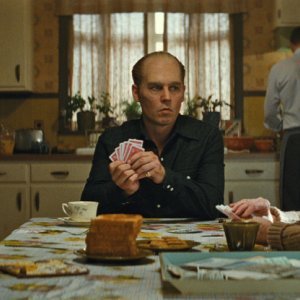 Black Mass - L'ultimo gangster: Johnny Depp gioca a carte seduto a tavola in una scena del film