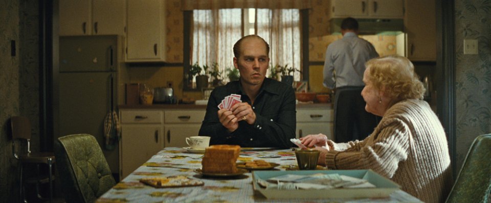 Black Mass - L'ultimo gangster: Johnny Depp gioca a carte seduto a tavola in una scena del film