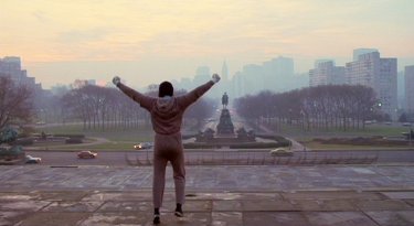 Rocky: Sylvester Stallone alza le braccia sulla scalinata di Philadelphia
