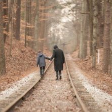 Cell: una scena ambientata nei boschi in cui John Cusack tiene per mano un bambino