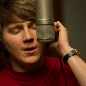 Love & Mercy: un primo piano di Paul Dano impegnato a cantare