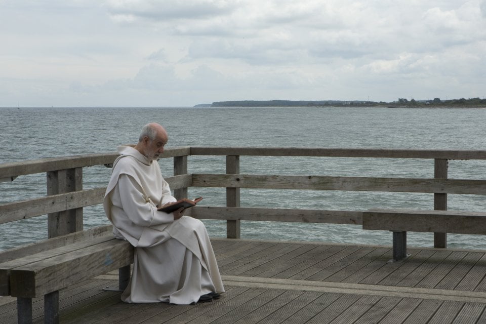 Le confessioni: Toni Servillo intento a leggere in una scena del film