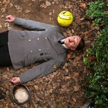 Lui è tornato: Oliver Masucci steso a terra da una pallonata in una scena del film