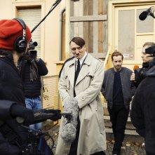 Lui è tornato: Oliver Masucci circondato dalla stampa in una scena del film