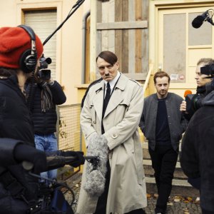 Lui è tornato: Oliver Masucci circondato dalla stampa in una scena del film