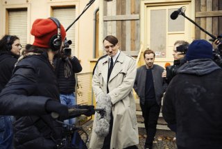 Lui è tornato: Oliver Masucci circondato dalla stampa in una scena del film