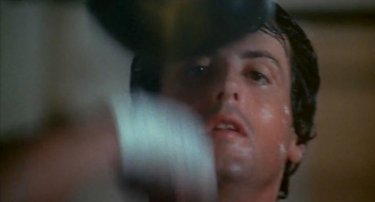Rocky: un primo piano di Sylvester Stallone mentre si allena al sacco