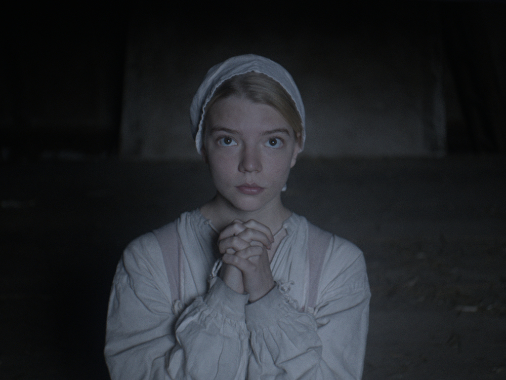 Thomasin (Anya Taylor-Joy) prega in una scena di The Witch di Robert Eggers
