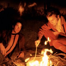 Belli e dannati: River Phoenix e Keanu Reeves davanti a un fuoco in una scena del film