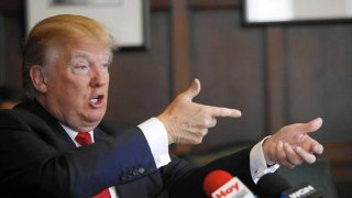 Donald Trump nell'atto di imbracciare un fucile
