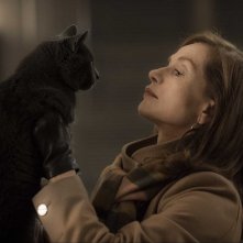 Elle: una assorta Isabelle Hupper con un gatto in un momento del film