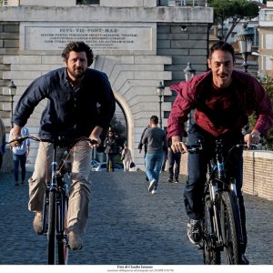 Questione di karma: Elio Germano e Fabio De Luigi corrono in bicicletta in una scena del film