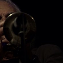 Enrico Rava. Note necessarie: Rava intento a suonare la tromba in un momento del documentario