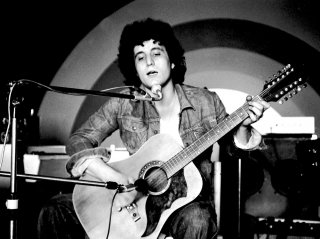 Pino Daniele - Il tempo resterà: il cantante napoletano in un'immagine d'archivio in cui canta sul palco