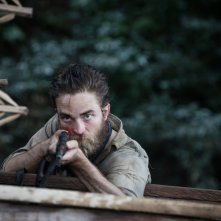 Civiltà perduta: Robert Pattinson con un fucile in mano in una scena del film