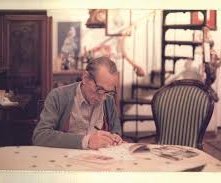 Eduardo De Filippo seduto ad un tavolo, impegnato a scrivere