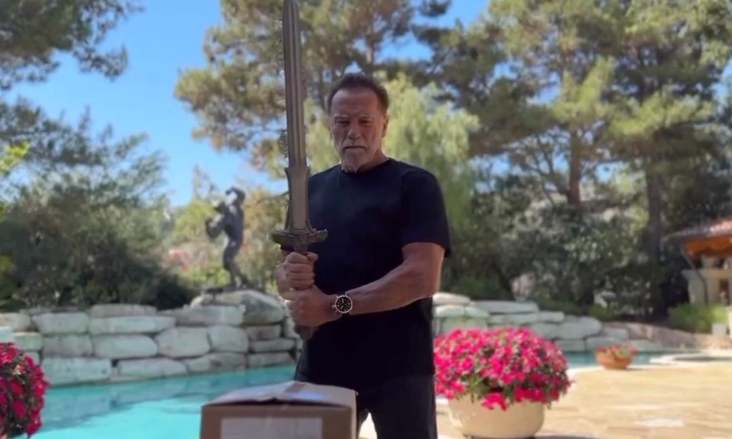 Arnold Schwarzenegger usa la spada di Conan il Barbaro per aprire le scatole del suo nuovo libro