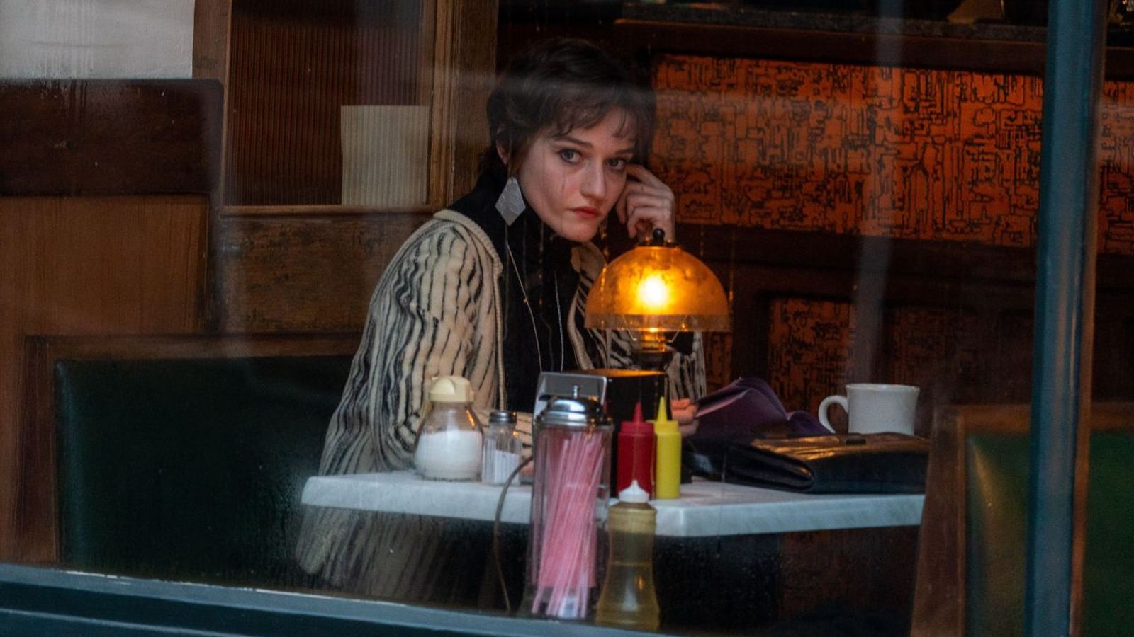 Julia Garner seduta al tavolo di un locale