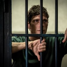 Libera. Matteo Martari dietro le sbarre in una scena della serie.