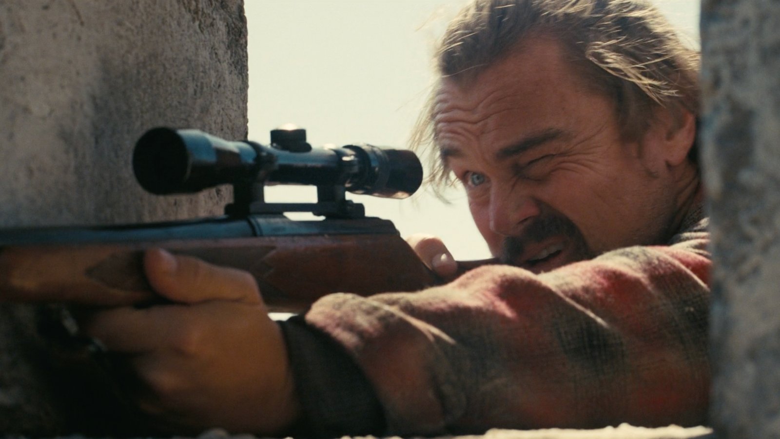 Leonardo DiCaprio col fucile spianato in una scena