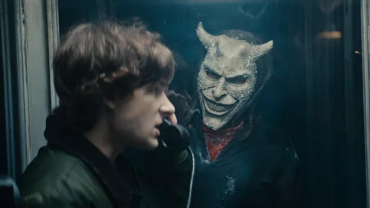 Mason Thames in una cabina telefonica minacciato da Ethan Hawke