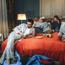 Il nascondiglio: i membri della famiglia guardano la tv sul letto matrimoniale