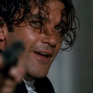 Assassins: un primo piano di Antonio Banderas con la pistola spianata