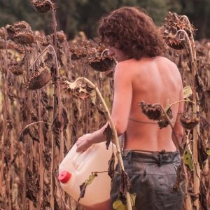 Eva: Carol Duarte nel campo di girasoli con in mano una tanica